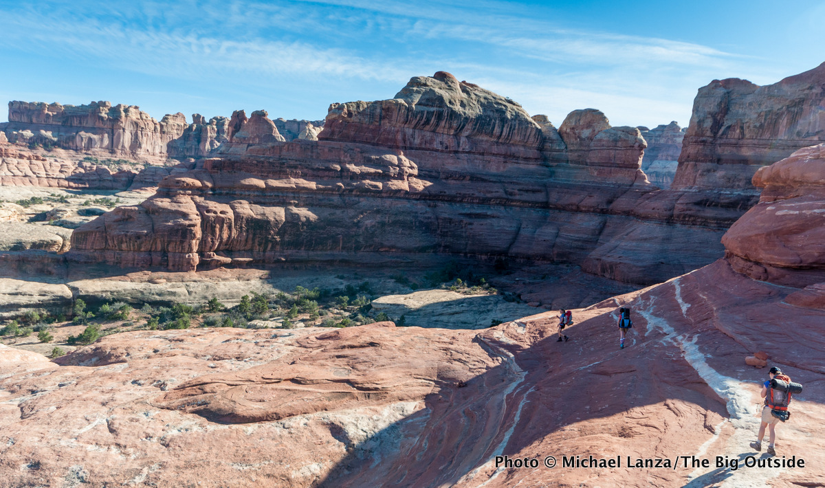 Young kids backpacking over the Big Spring Canyon-Squaw Canyon pass in the Needles District, Canyonlands National Park.
