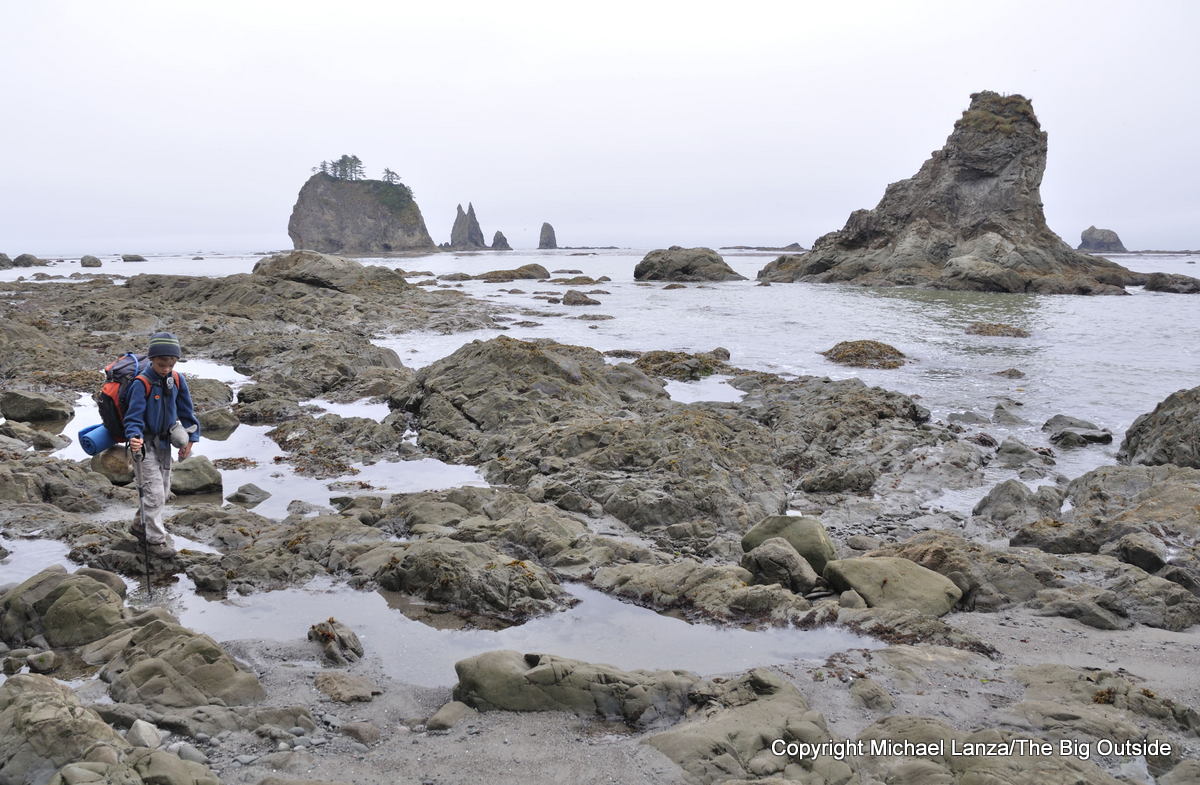 A young boy backpacking the Olympic coast near Strawberry Point, Olympic National Park.