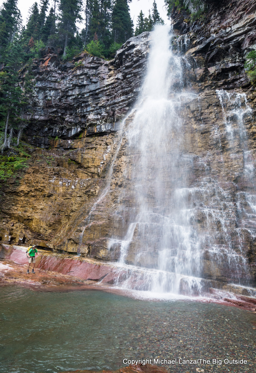 A backpacker below Virginia Falls in Glacier National Park.