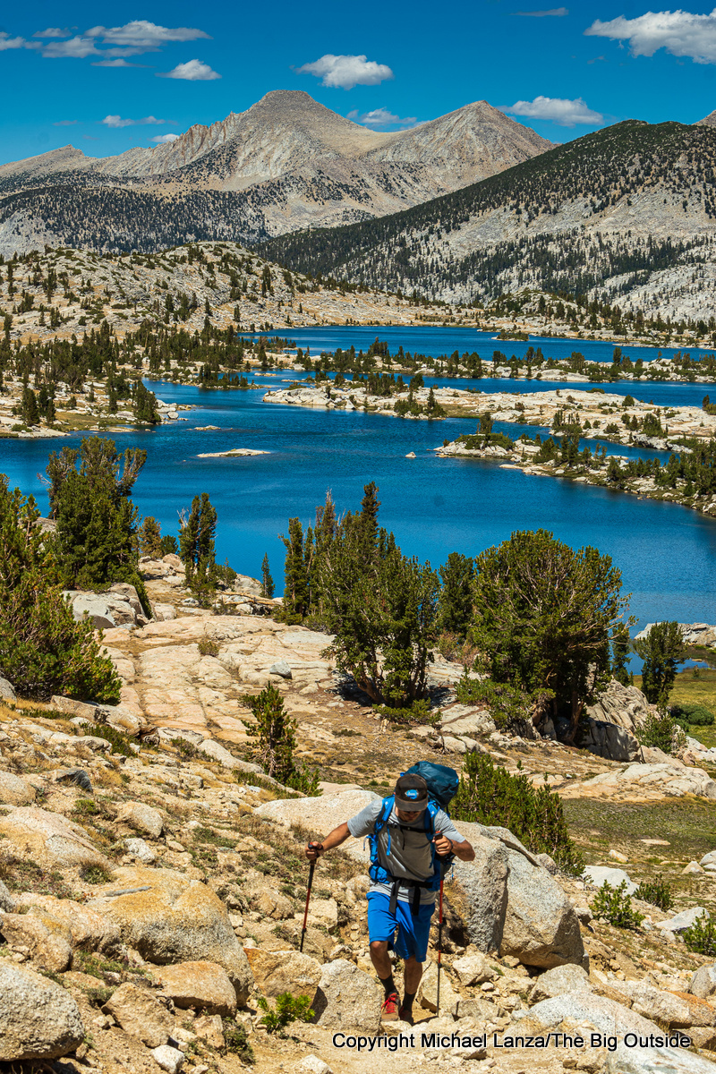 A backpacker hiking the John Muir Trail above Marie Lake in the John Muir Wilderness, High Sierra.
