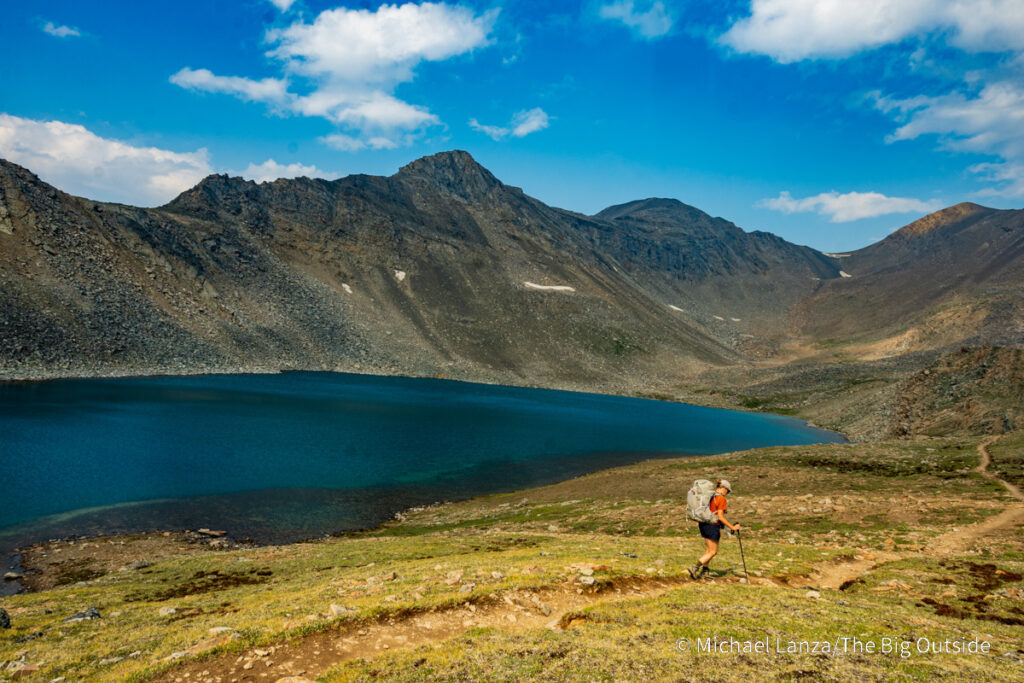 A backpacker hiking past Curator Lake along the Skyline Trail in Jasper National Park. A backpacker hiking past Curator Lake along the Skyline Trail in Jasper National Park.