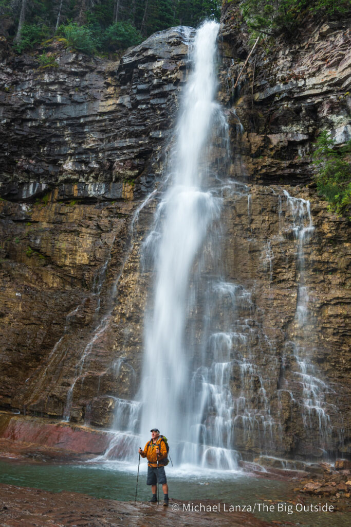 A backpacker beneath Virginia Falls along the Continental Divide Trail in Glacier National Park. A backpacker beneath Virginia Falls along the Continental Divide Trail in Glacier National Park.