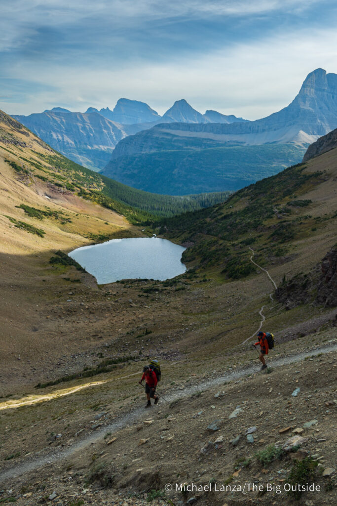 Backpackers hiking the Ptarmigan Tunnel Trail above Ptarmigan Lake in Glacier National Park. Backpackers hiking the Ptarmigan Tunnel Trail above Ptarmigan Lake in Glacier National Park.