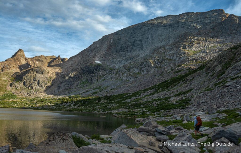 A backpacker hiking around Pyramid Lake in the Wind River Range, Wyoming. A backpacker hiking around Pyramid Lake in the Wind River Range, Wyoming.