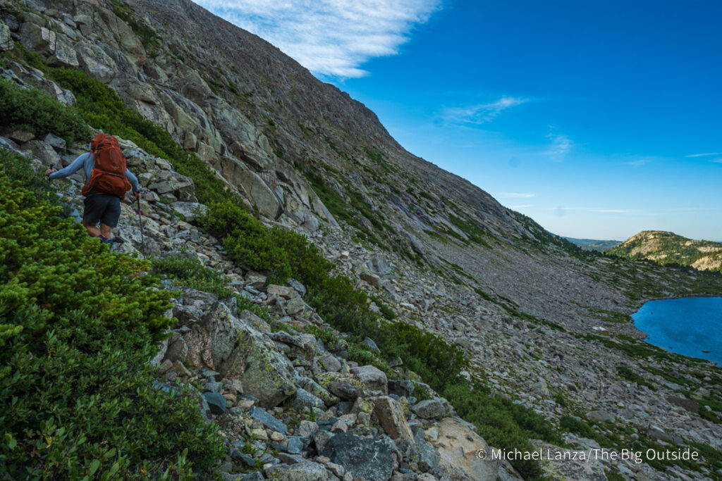 A backpacker hiking above Pyramid Lake in the Wind River Range, Wyoming. A backpacker hiking above Pyramid Lake in the Wind River Range, Wyoming.