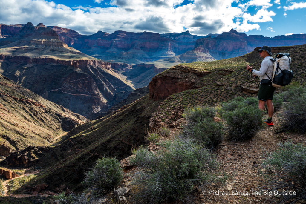 A backpacker hiking the Tonto Trail above Ruby Canyon in the Grand Canyon.