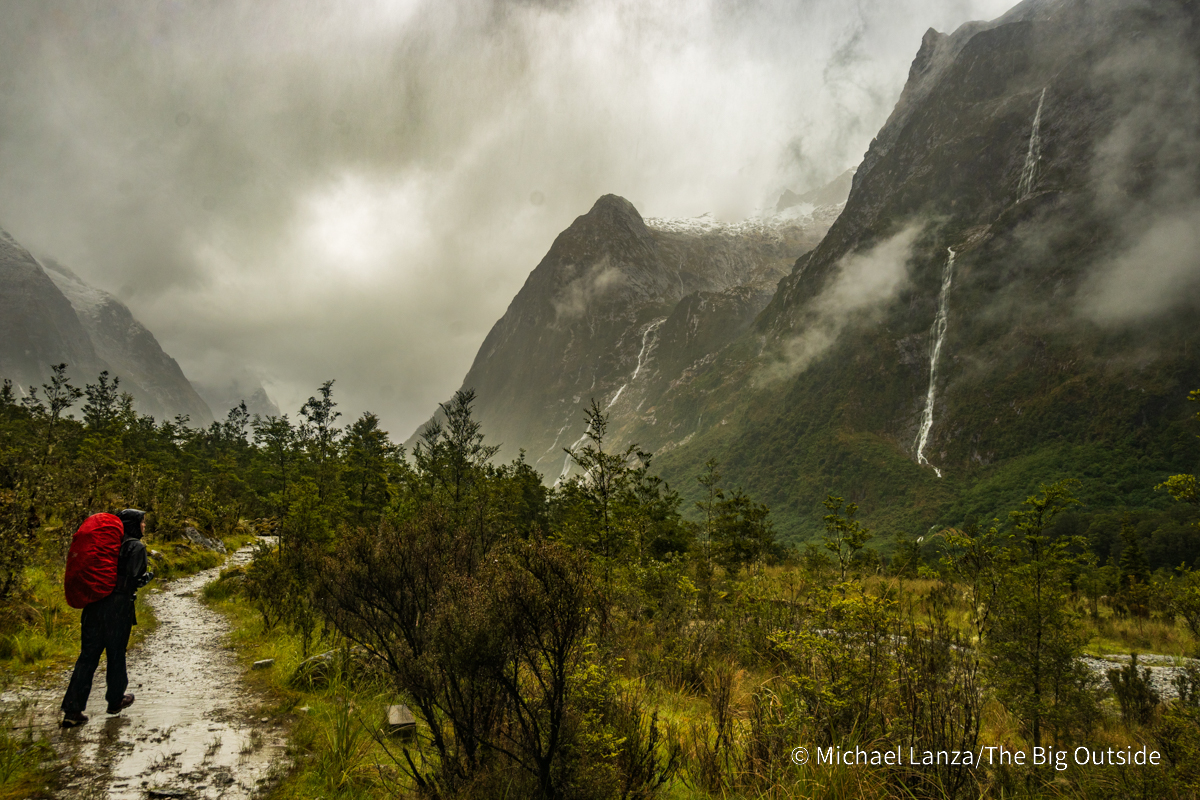 A trekker hiking the Milford Track up the Clinton River Valley to Mintauro Hut, Fiordland National Park, New Zealand.
